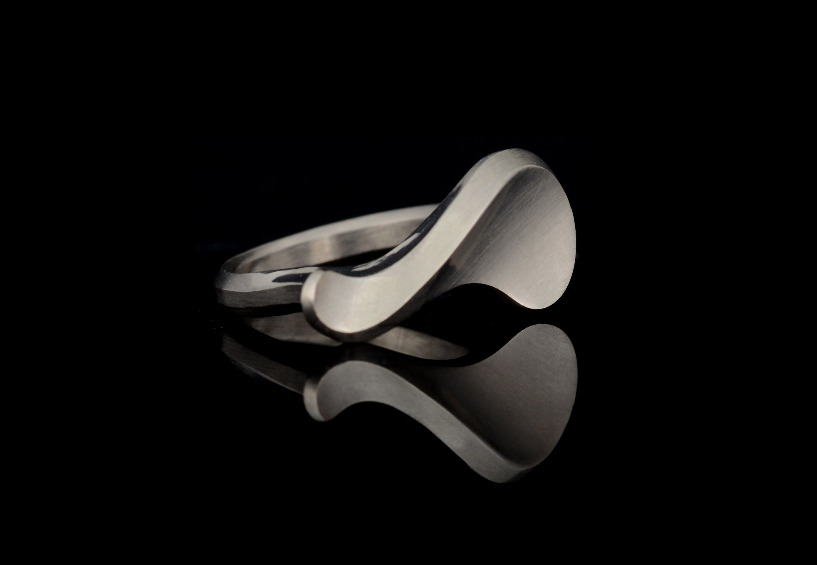 white gold sigma ring on black background